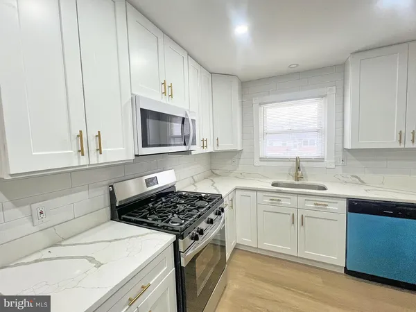 a kitchen with cabinets stainless steel appliances a sink and a stove