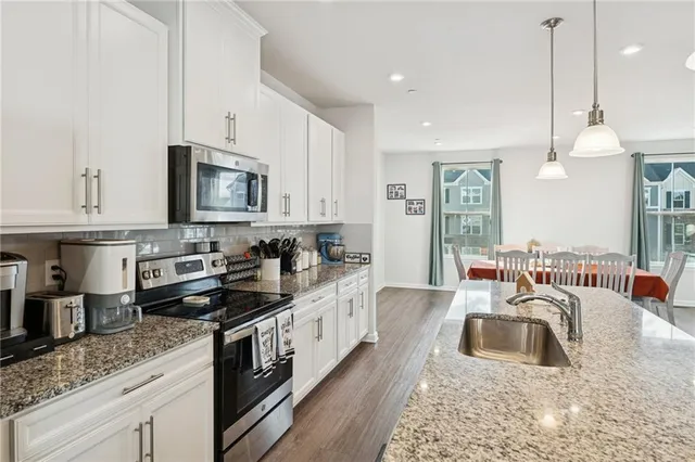 a large kitchen with stainless steel appliances granite countertop a sink a stove and a granite counter tops