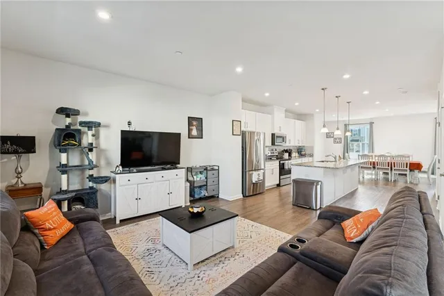 a living room with furniture a flat screen tv and a floor to ceiling window