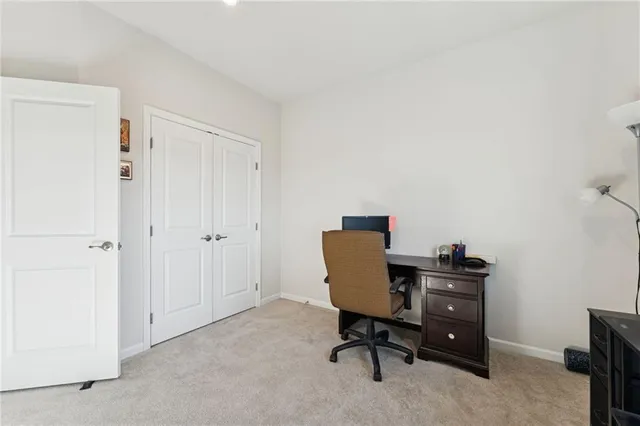 a view of a workspace with furniture and a window
