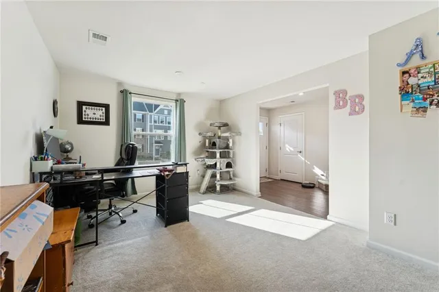 a view of a workspace with furniture and a window