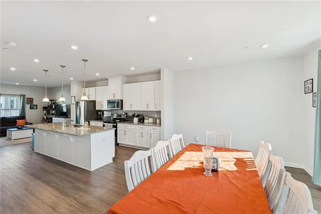a living room with stainless steel appliances furniture and a table