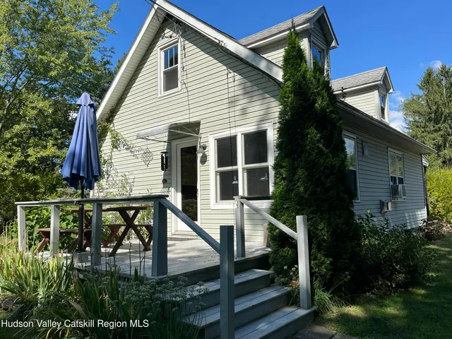 a view of house with a yard and sitting area