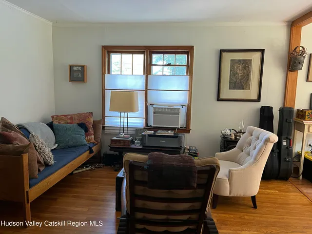a living room with furniture a flat screen tv and a window