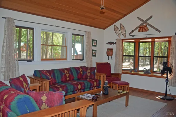 a living room with furniture a flat screen tv and a large window