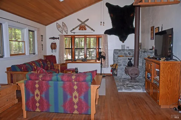 a living room with furniture a flat screen tv and a floor to ceiling window