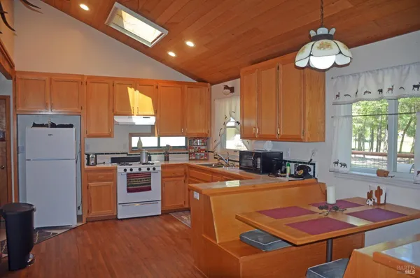 a kitchen with stainless steel appliances granite countertop a stove refrigerator a sink dishwasher and microwave with wooden floor