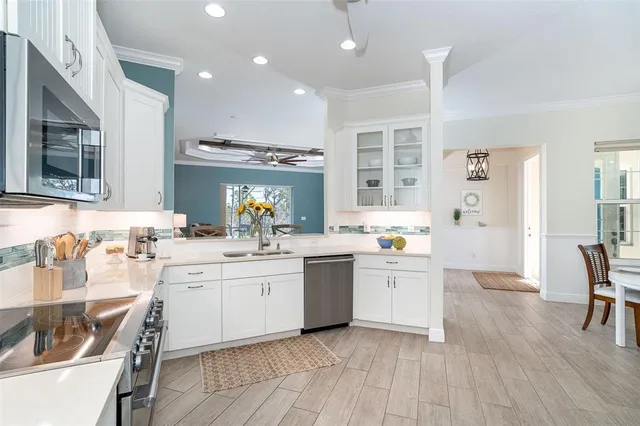 a kitchen with white cabinets stainless steel appliances and sink