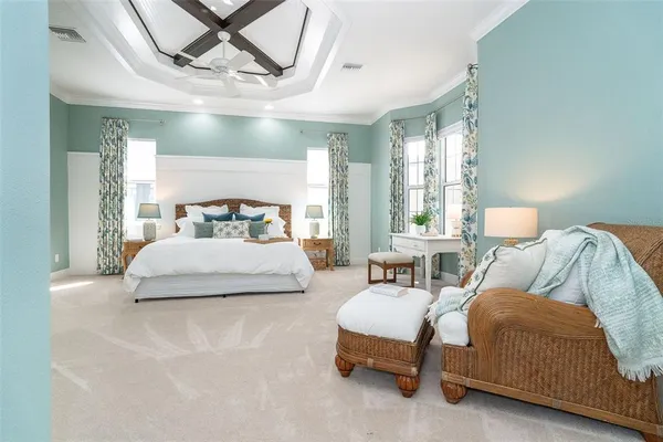 a bedroom with a large bed and a chandelier