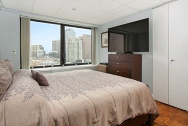 a bedroom with a bed and a large window