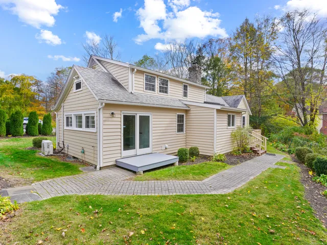 a view of a house with a yard chairs and table in patio
