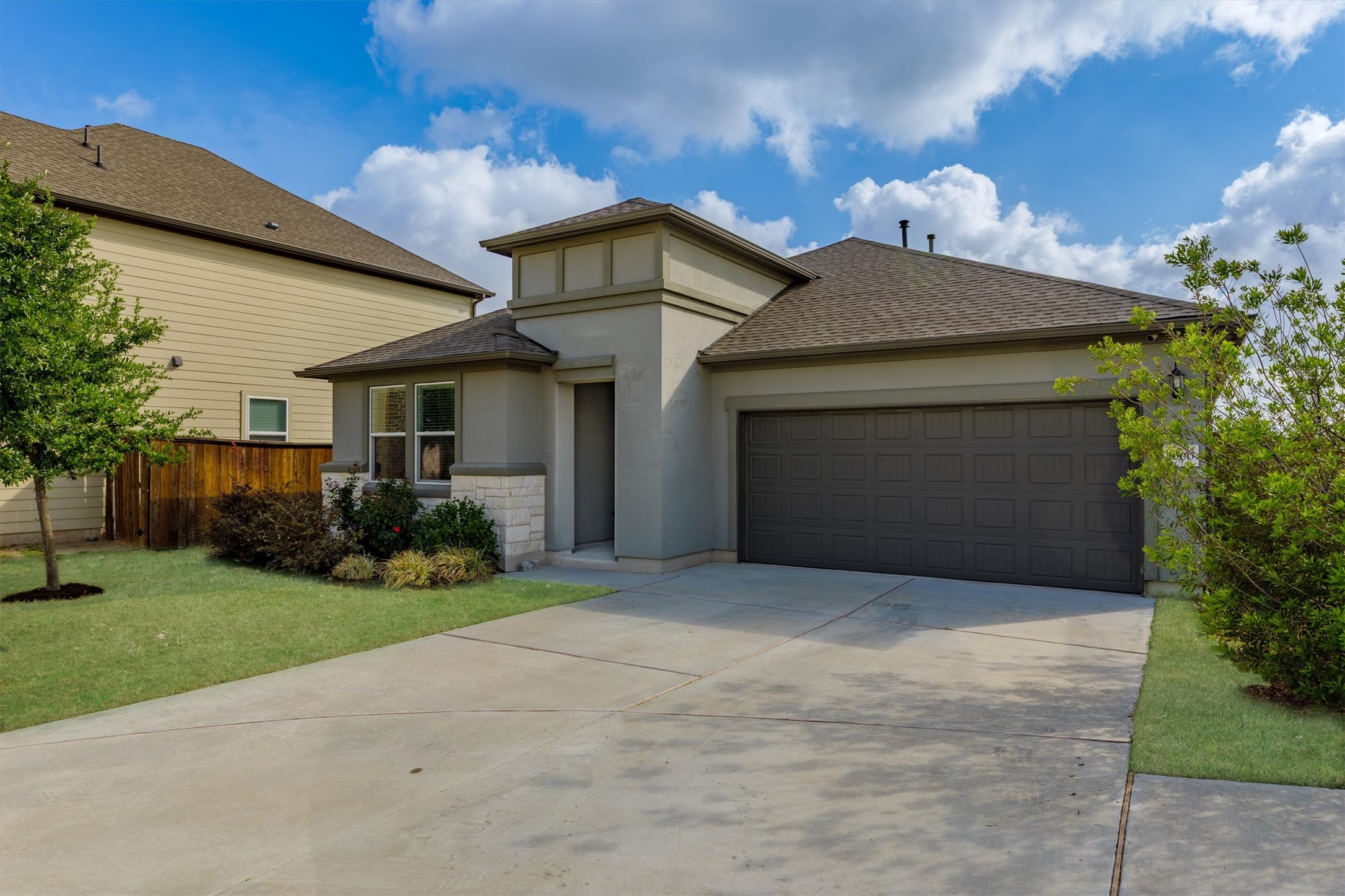 1000 Moose Road Hutto, TX 78634 - Photo 2 of 29 Prairie-style home with roof with shingles, an attached garage, driveway, stucco siding, and stone siding