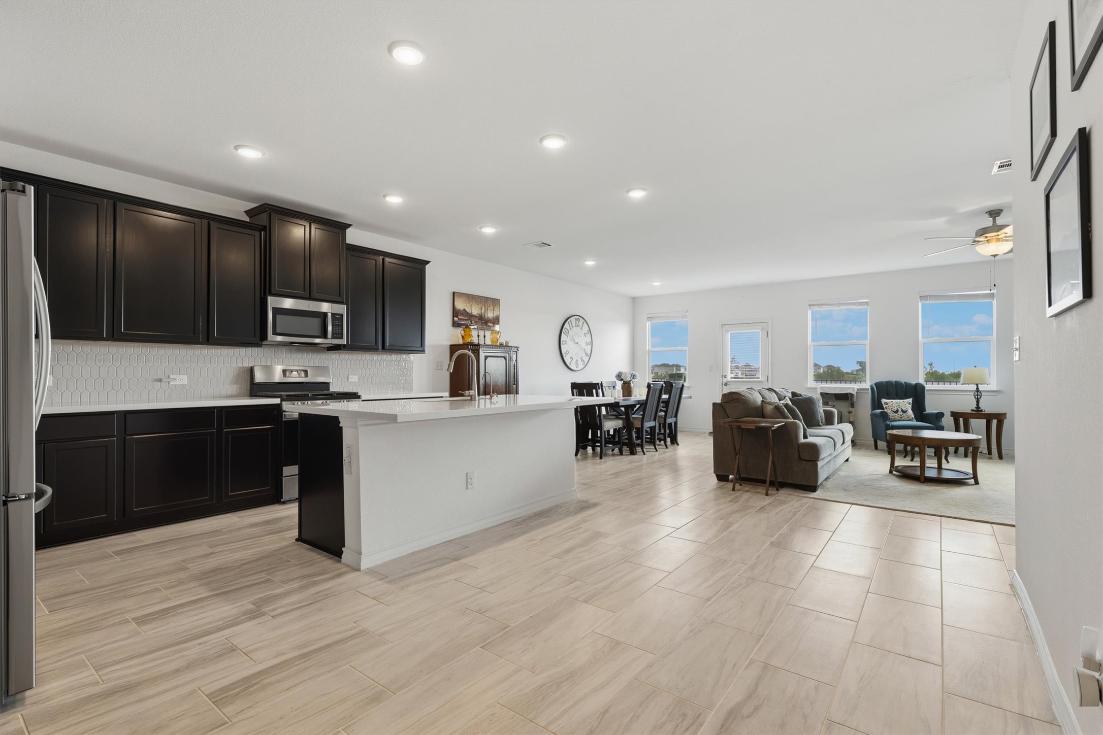 1000 Moose Road Hutto, TX 78634 - Photo 28 of 29 Kitchen featuring open floor plan, stainless steel appliances, a center island with sink, decorative backsplash, and ceiling fan