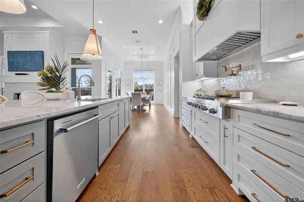 a kitchen with stainless steel appliances sink stove and cabinets