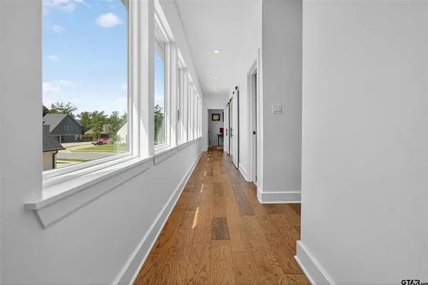 a view of a hallway with wooden floor and staircase