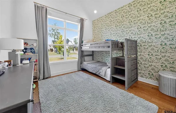 a living room with stainless steel appliances furniture a rug and a window