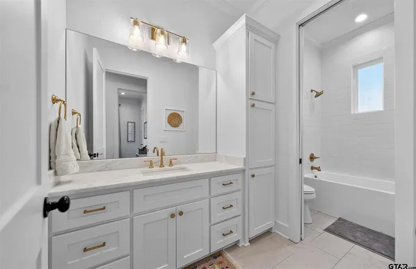 a bathroom with a double vanity sink a mirror and a bathtub