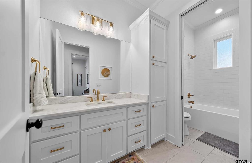 1572 Maple Lane Tyler, TX 75703 - Photo 31 of 40 a bathroom with a double vanity sink a mirror and a bathtub