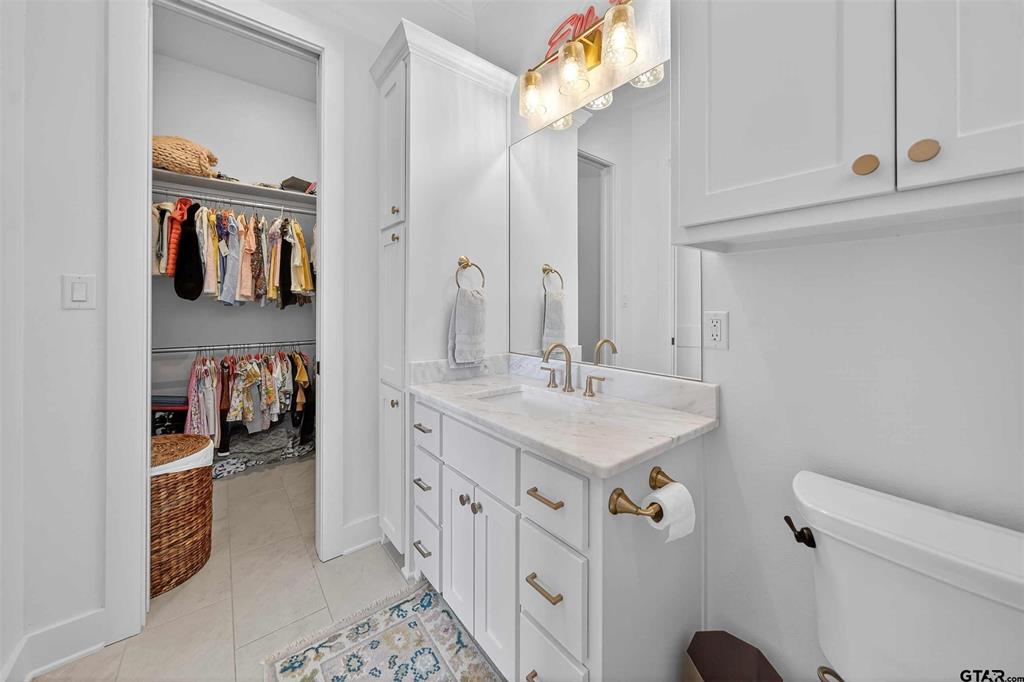 1572 Maple Lane Tyler, TX 75703 - Photo 35 of 40 a bathroom with a sink a mirror and a toilet
