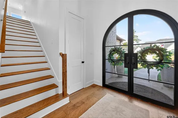 a view of a hallway with wooden floor and windows