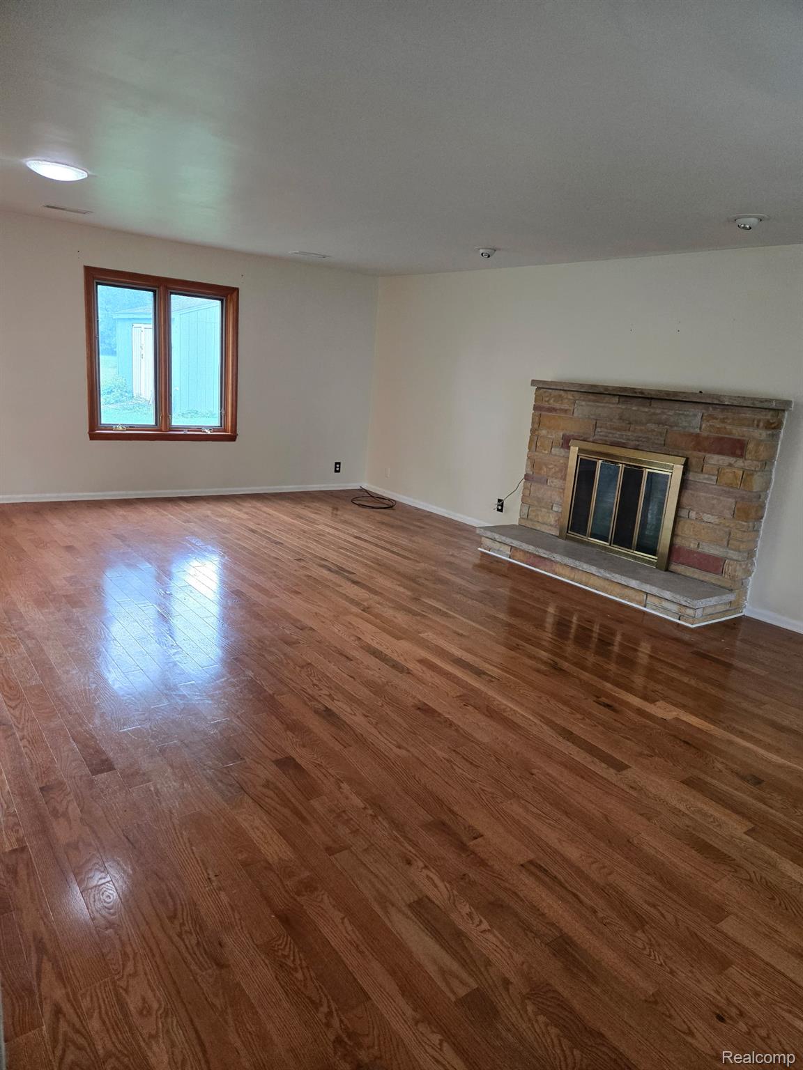 3176 East Fisher Road Bay City, MI 48706 - Photo 6 of 25 Unfurnished living room featuring wood finished floors, a fireplace, and recessed lighting