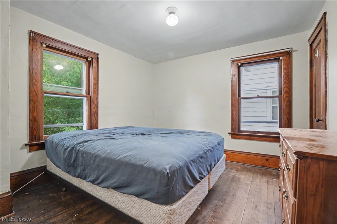 456 Delmar Avenue Akron, OH 44310 - Photo 18 of 27 Bedroom featuring two windows with wood trim, wood-finish flooring, and a ceiling-mounted light fixture
