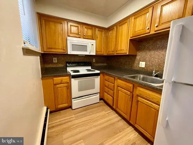 a kitchen with stainless steel appliances granite countertop wooden cabinets a stove top oven a sink and dishwasher