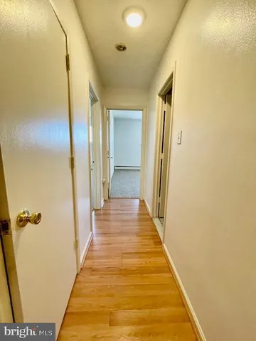 a view of a hallway with wooden floor and staircase