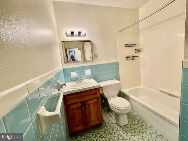 a bathroom with a granite countertop toilet sink and mirror