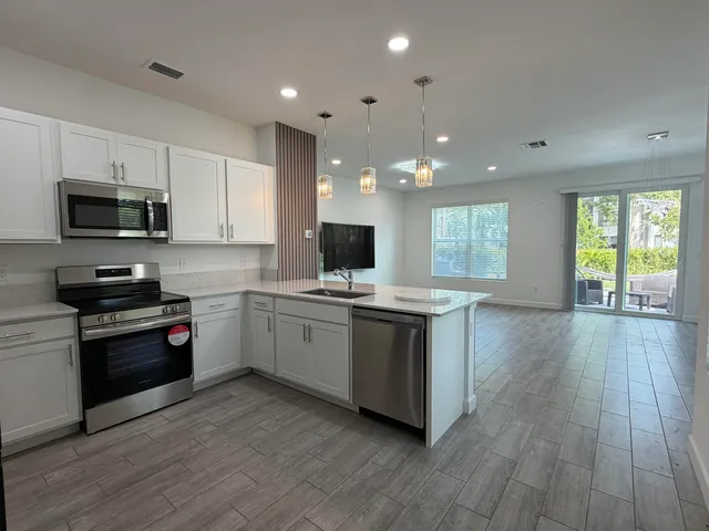 a kitchen with stainless steel appliances kitchen island granite countertop a stove a sink and a microwave