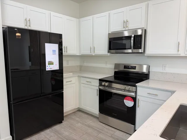 a kitchen with stainless steel appliances granite countertop a refrigerator stove and microwave