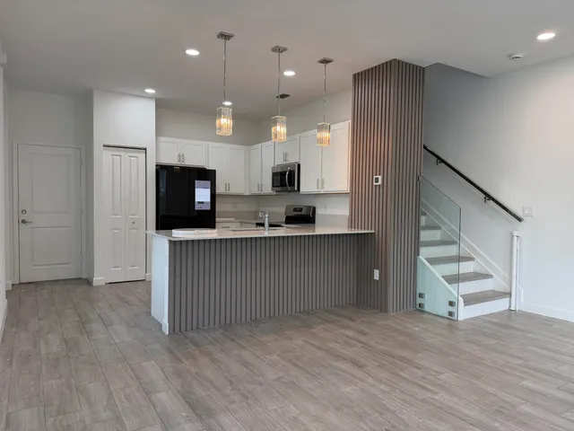 a open kitchen with white cabinets and stainless steel appliances