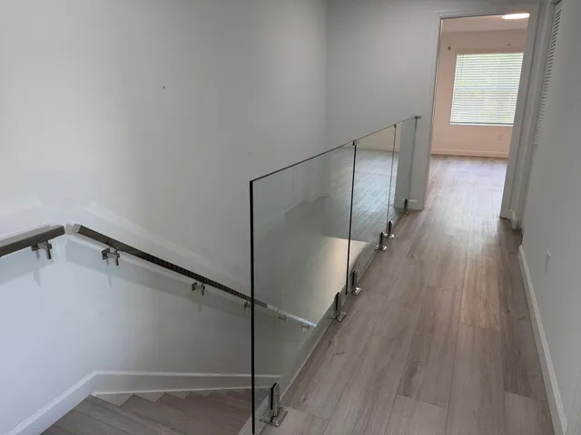 a view of a hallway with wooden floor and staircase