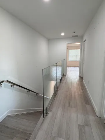 a view of empty room with wooden floor