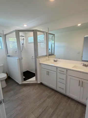 a spacious bathroom with double vanity and a mirror