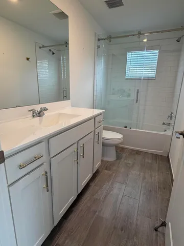 a bathroom with a double vanity sink toilet and shower