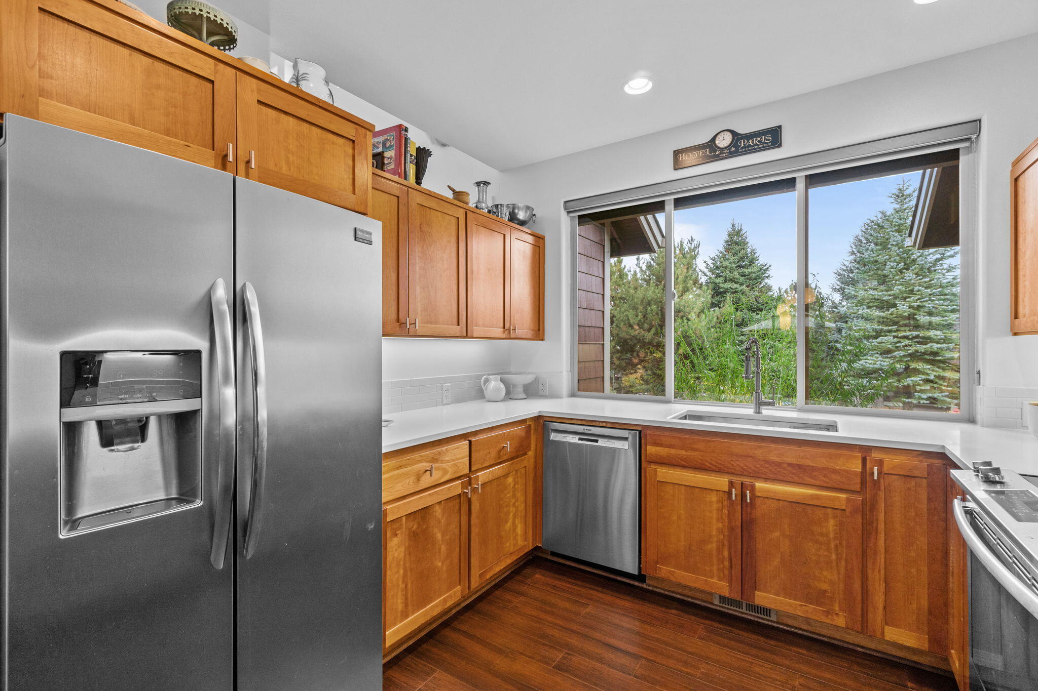 10942 Village Loop Redmond, OR 97756 - Photo 41 of 45 a kitchen with stainless steel appliances granite countertop a refrigerator a sink a stove with wooden cabinets and wooden floor