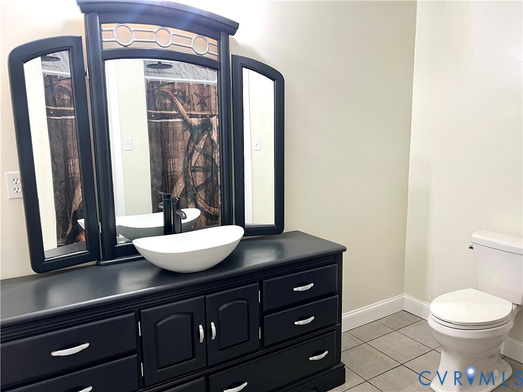 2049 Riddle Road Blackstone, VA 23824 - Photo 16 of 44 a bathroom with a granite countertop sink toilet and mirror