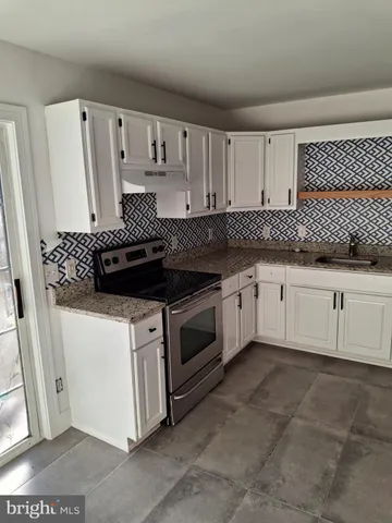 a kitchen with granite countertop white cabinets and white appliances