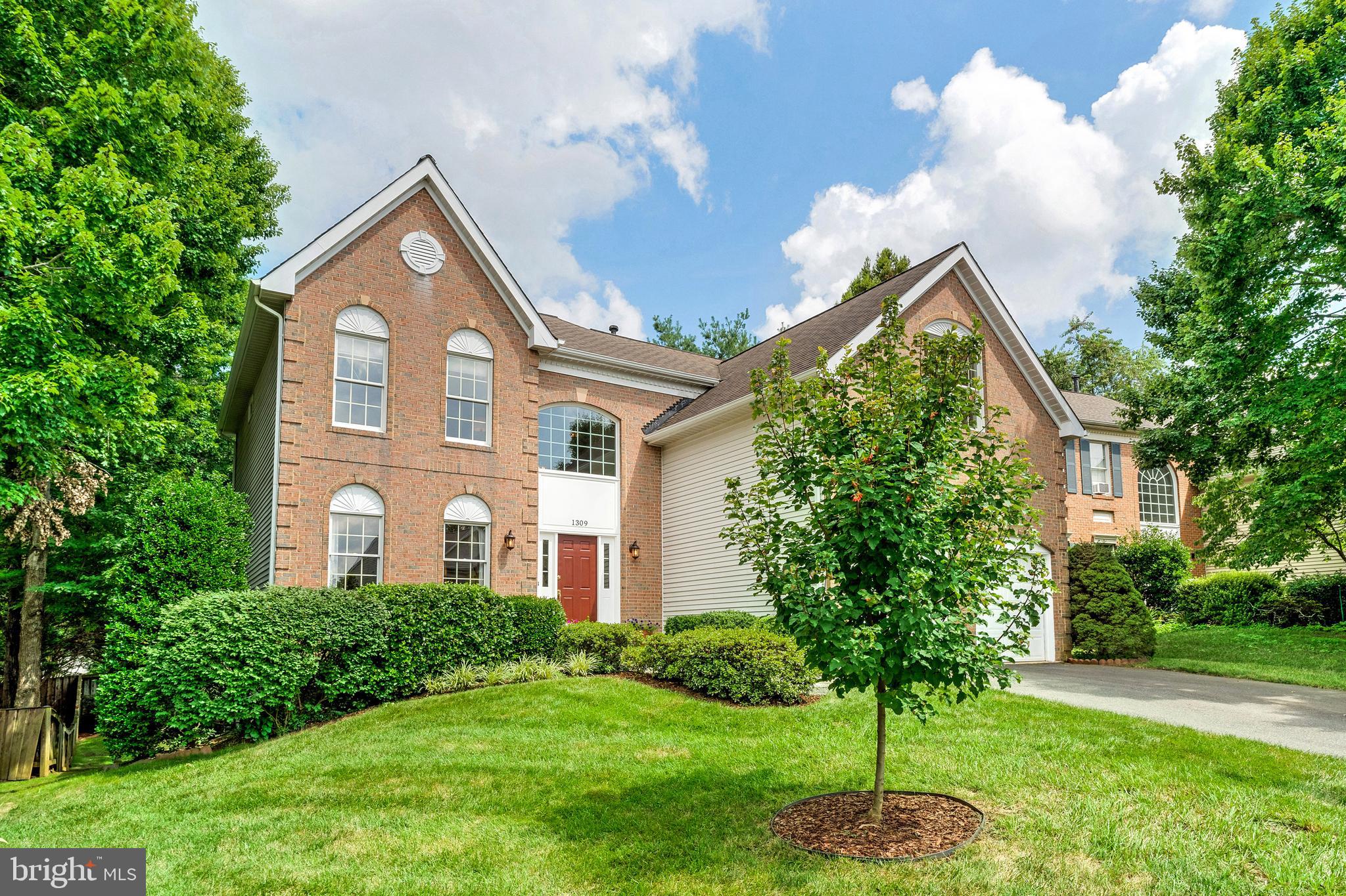 1309 Murray Downs Way Reston, VA 20194 - Photo 59 of 63 a front view of a house with a yard and garage