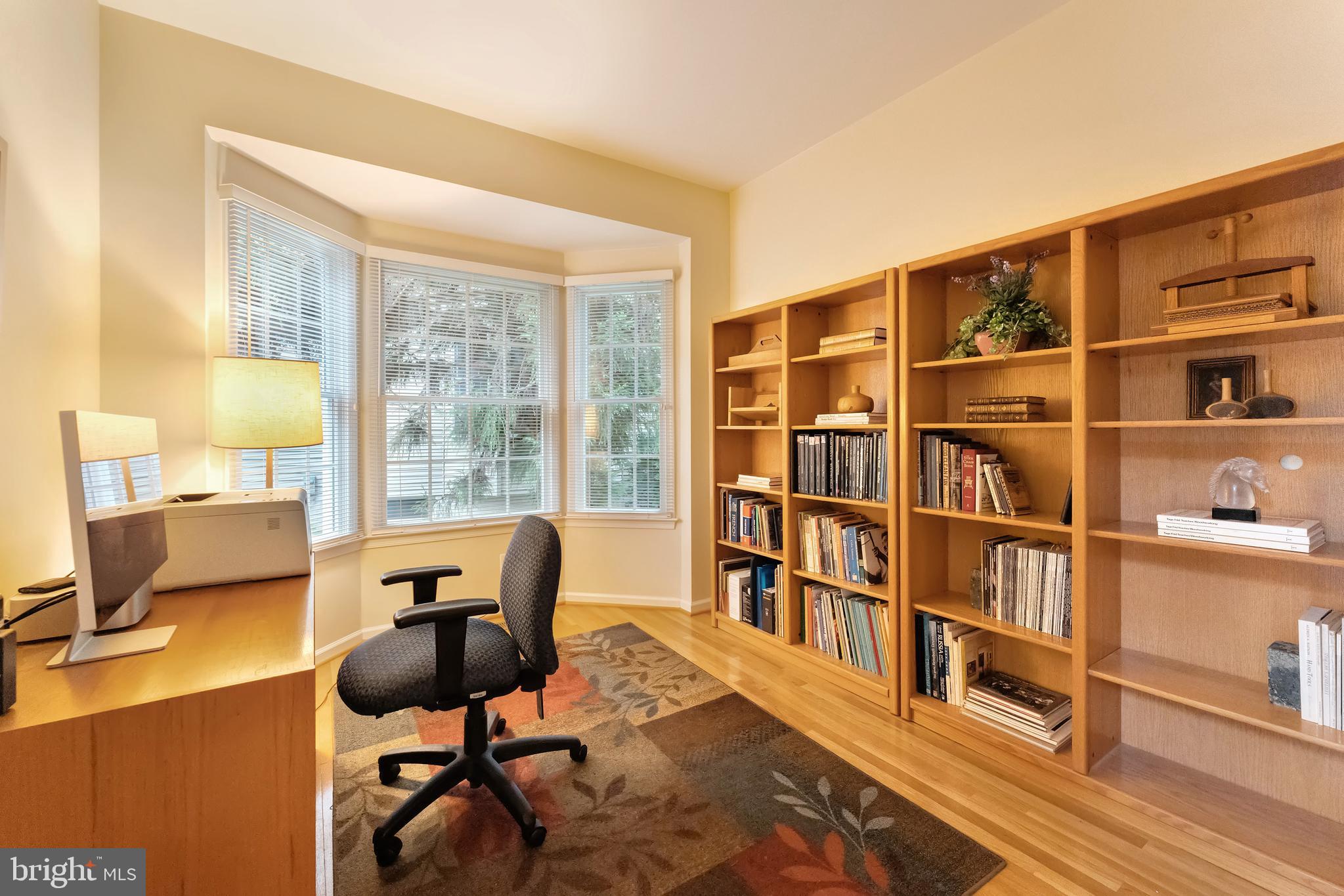 1309 Murray Downs Way Reston, VA 20194 - Photo 10 of 63 a view of a workspace with furniture and a bookshelf