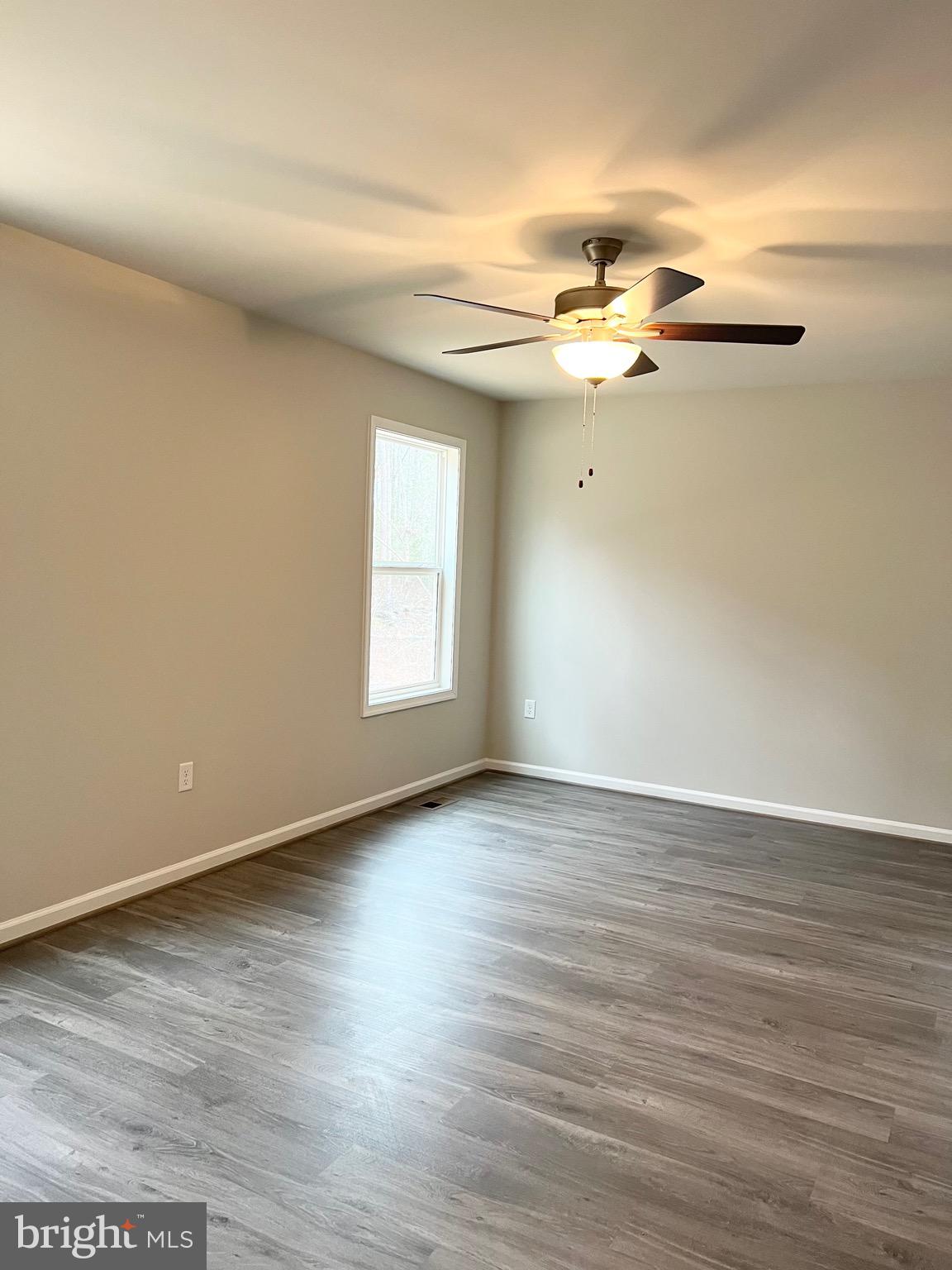 255 9th Street Colonial Beach, VA 22443 - Photo 12 of 18 an empty room with wooden floor fan and windows