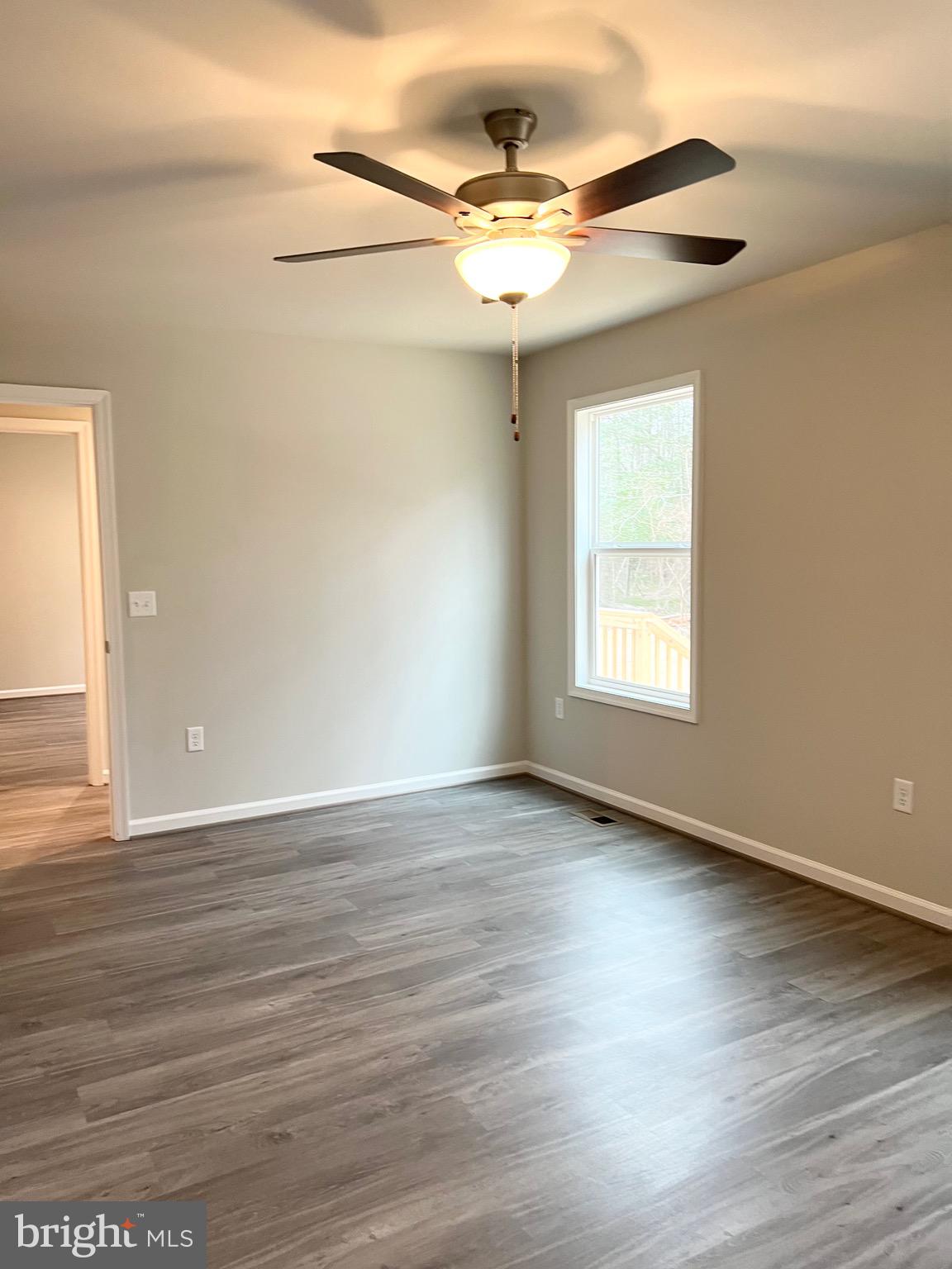 255 9th Street Colonial Beach, VA 22443 - Photo 16 of 18 an empty room with wooden floor fan and windows