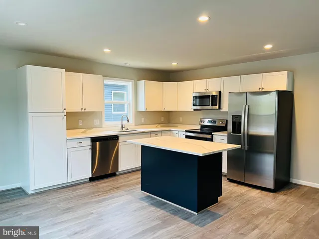 a kitchen with stainless steel appliances granite countertop a refrigerator stove microwave and sink