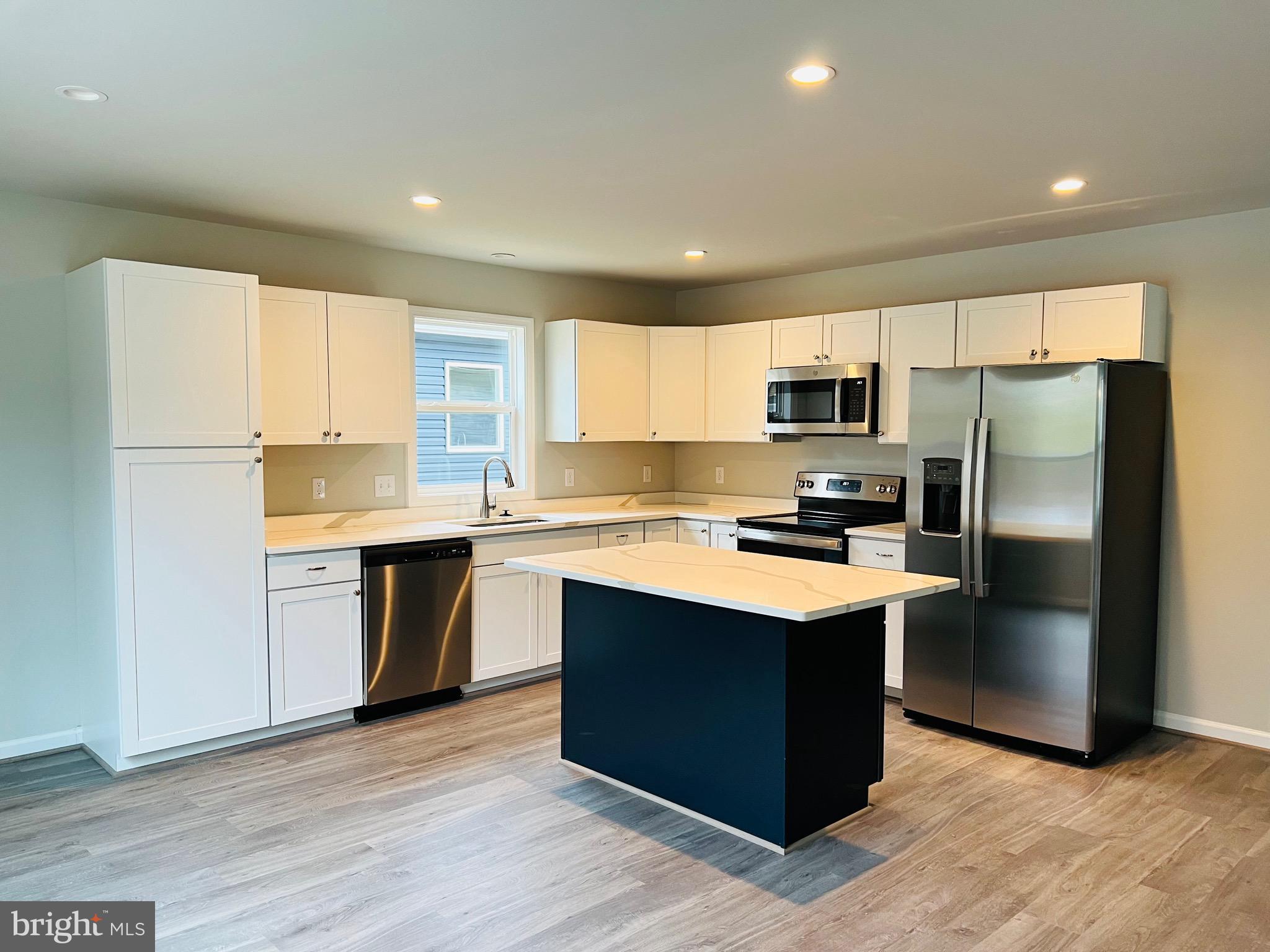 255 9th Street Colonial Beach, VA 22443 - Photo 6 of 18 a kitchen with stainless steel appliances granite countertop a refrigerator stove microwave and sink