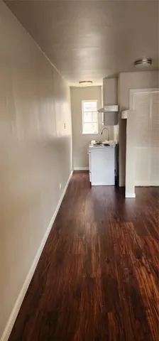 a view of empty room with wooden floor and window