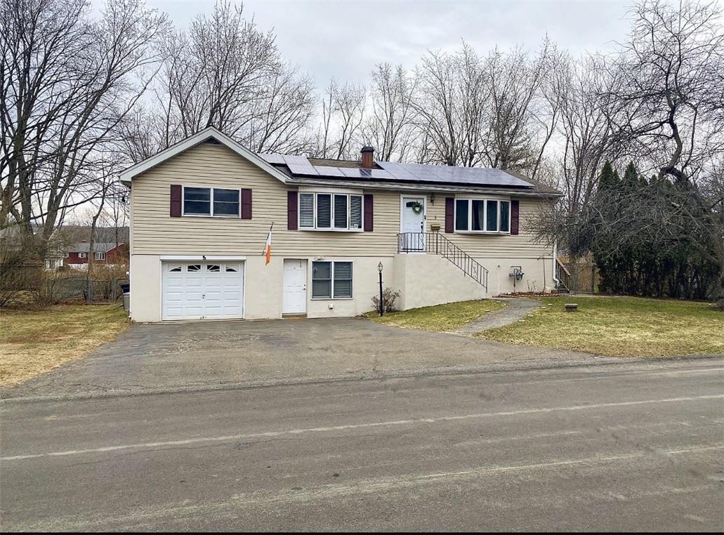 a view of a white house with a big yard and large trees