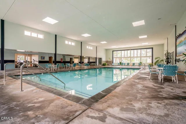 a swimming pool with kitchen view and potted plants