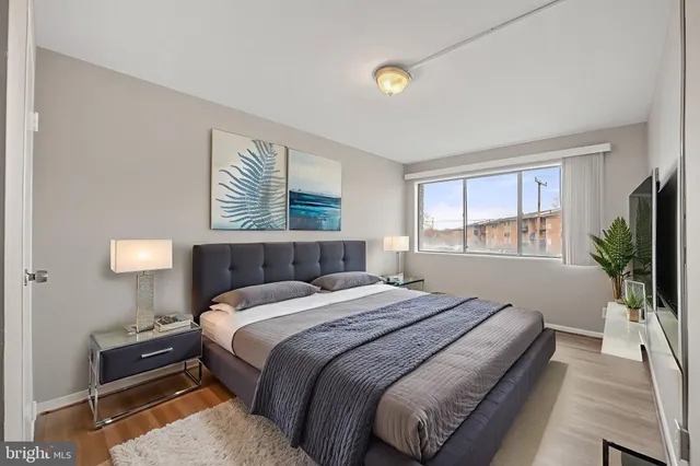 a bedroom with a large bed and a flat tv screen on dresser