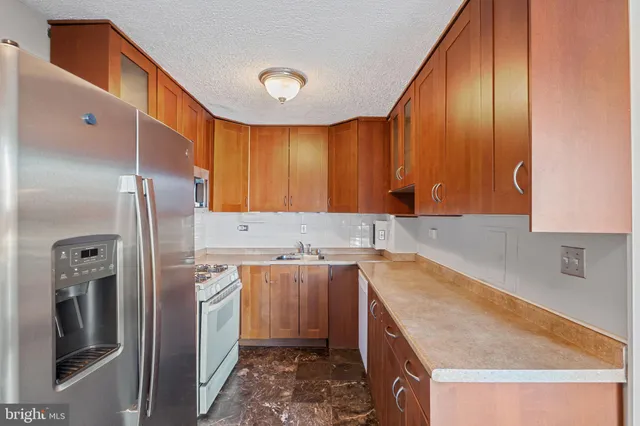 a kitchen with a sink a refrigerator and cabinets